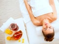 Woman laying on massage table near honey spa therapy ingre