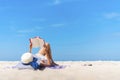 Woman laying and reading on the beach with blue sky in summer times. Royalty Free Stock Photo