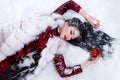 Woman laying on a snow near the bitten apple