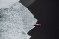 Woman laying on tropical beach black sand in white bikini Royalty Free Stock Photo