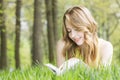 Woman lays on grass and reads book Royalty Free Stock Photo