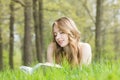 Woman lays on grass and reads book Royalty Free Stock Photo