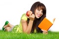 Woman lays on green grass and reads book. Royalty Free Stock Photo