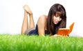 Woman lays on green grass and reads book. Royalty Free Stock Photo