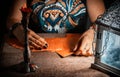 A woman lays out the tarot cards by the light of a lantern and a candle