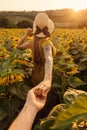 Woman Leading Man by Hand in Sunflower Field Royalty Free Stock Photo