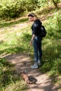 Woman leads Burmese cat on leash in park. Collared pet wandering outdoor adventure in summer