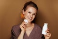 Woman with leaf earring using face cleansing milk and swab Royalty Free Stock Photo