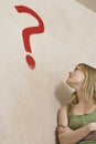 Woman Leaning Against Wall With Painted Question Mark Royalty Free Stock Photo