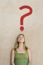 Woman Leaning Against Wall With Painted Question Mark Royalty Free Stock Photo
