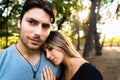 Woman leaning on her boyfriend`s shoulder, while he looks at the camera Royalty Free Stock Photo