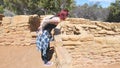 Woman Leaning Over to Peer Into An Ancient Indian Dwelling