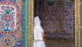 Woman leaning to a wall with colored tiles Nasir al-Mulk Mosque, Shiraz, Iran