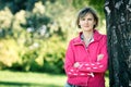 Woman leaning on the tree stem