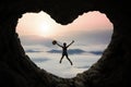 Woman leaps inside cave at mountain Royalty Free Stock Photo