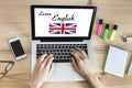 Woman learning English online with computer at home, british flag