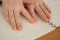 A woman learns the Braille alphabet using a decoder.