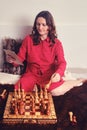 Woman learns chess while sitting with a tablet at a chessboard, lessons online