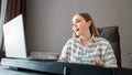 Woman learns music singing vocals playing piano online using laptop at home interior. Teenager girl sings song play piano Royalty Free Stock Photo