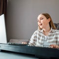 Woman learns music singing vocals playing piano online using laptop at home interior. Teenager girl sings song play Royalty Free Stock Photo