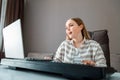 Woman learns music singing vocals playing piano online using laptop at home interior. Teenager girl sings song and plays Royalty Free Stock Photo