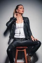 Woman in leather clothes with one hand behind her neck Royalty Free Stock Photo