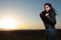 Woman in leather jacket and scarf looking away in the dusk Royalty Free Stock Photo