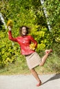 Woman with leaves in hands in jump in autumn Royalty Free Stock Photo