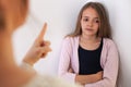 Woman lecturing her bored teenager daughter - pointing with finger