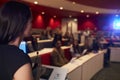 Woman lecturing students in lecture theatre, focus foreground