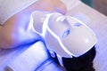 Woman with led light therapy facial and neck beauty mask photon therapy. Home skincare and me time concept