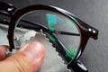 Woman left hand cleaning shortsighted or nearsighted eyeglasses by microfibre cleaning cloths, On black background, Close up