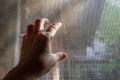 Woman left hand touching dust Dirty mosquito wire screen window, Light & Shadow shot, Silhouette, Close up shot