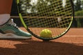 Woman leg, racket and tennis ball on clay court Royalty Free Stock Photo