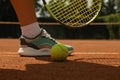 Woman leg racket and tennis ball on clay court Royalty Free Stock Photo