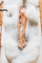 Woman legs in bath foam in spa hotel. Top view Royalty Free Stock Photo