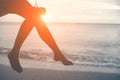 Woman legs at beach on wooden swing with sunset. Single woman co