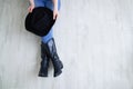 Woman legs in black cowboy boots with cowboy hat. Sitting on a gray wooden background Royalty Free Stock Photo