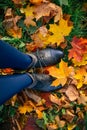 Woman legs in boots on fallen autumn leaves Royalty Free Stock Photo