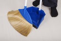 Woman legs with broom and dustpan sweeping floor