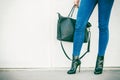 Woman legs in heels shoes handbag in hand Royalty Free Stock Photo