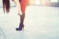Woman legs in high heels black boots on street background, soft Royalty Free Stock Photo