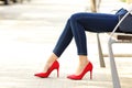 Woman legs with jeans and high heels in a bench Royalty Free Stock Photo