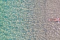 Woman legs in relaxing, calm turquoise, transparent sea water with stones. Summer vacation. Blue ocean lagoon. Drone, copter Royalty Free Stock Photo