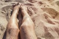 Woman legs on a sand beach, toned. Summer, holiday concept.