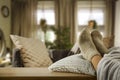 Woman legs in socks on the table with the spring sun. Nice cozy home interior background.