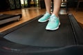 Woman legs with sport shoes running on treadmill in fitness gym