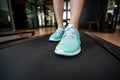 Woman legs with sport shoes running on treadmill in fitness gym