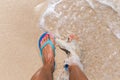 Woman legs stands in sea water on a tropic beach Royalty Free Stock Photo