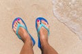 Woman legs stands in sea water on a tropic beach Royalty Free Stock Photo